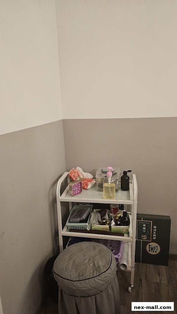 A trolley with various beauty products and a stool in a room.