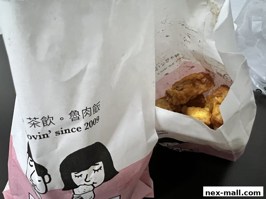 A paper bag from 'I Love Taimei' with fried chicken pieces inside.