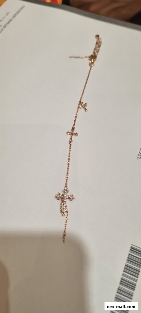 A delicate rose gold bracelet with multiple cross charms, some adorned with small stones.