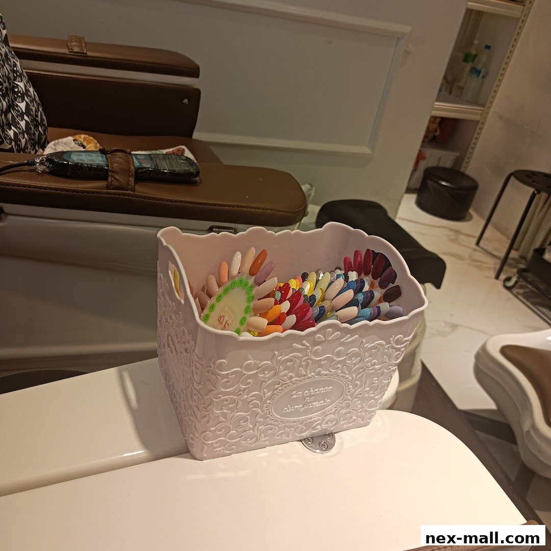 A pink decorative basket filled with various nail polish color swatches inside a nail salon.