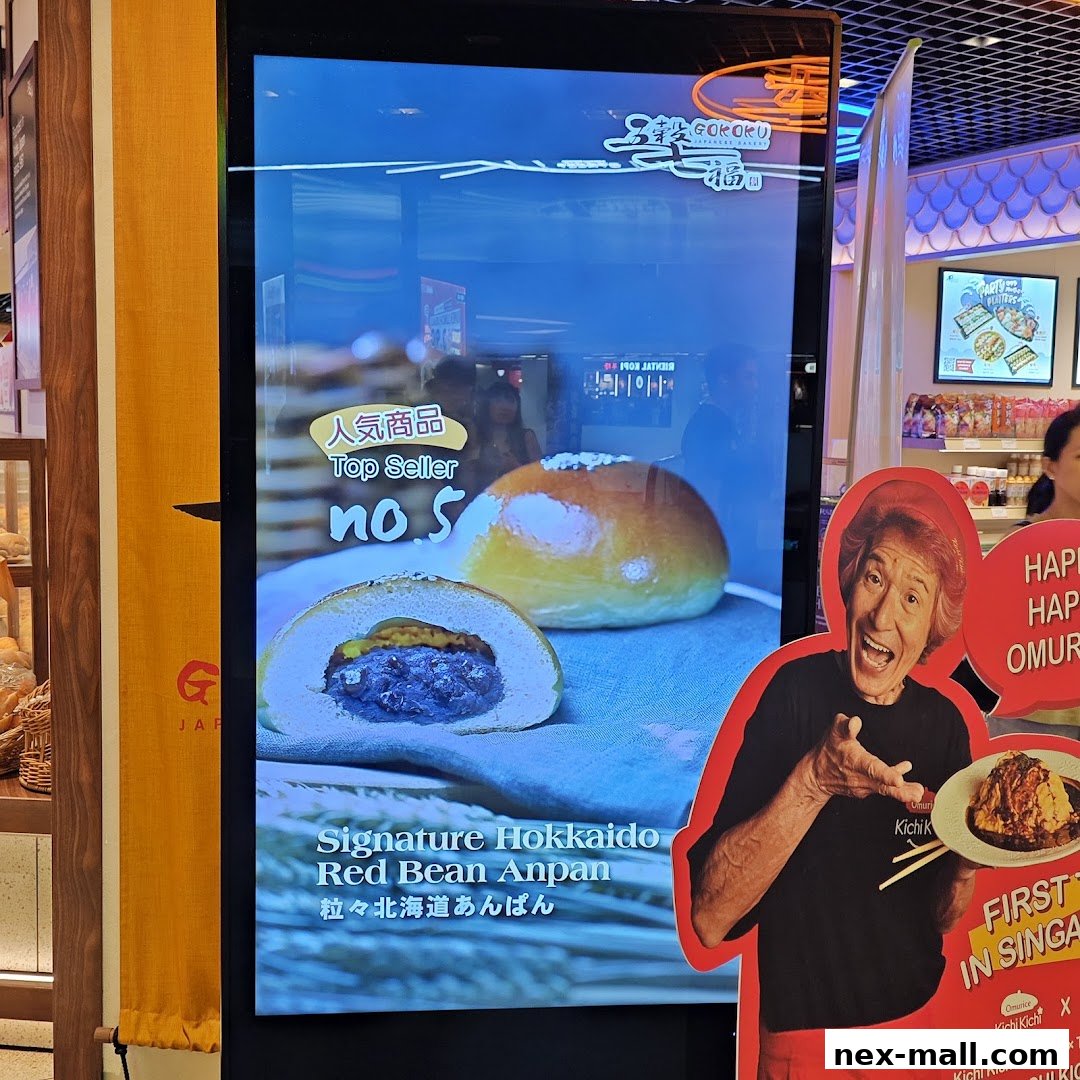A digital display showcasing a signature red bean anpan and a chef promoting a dish.