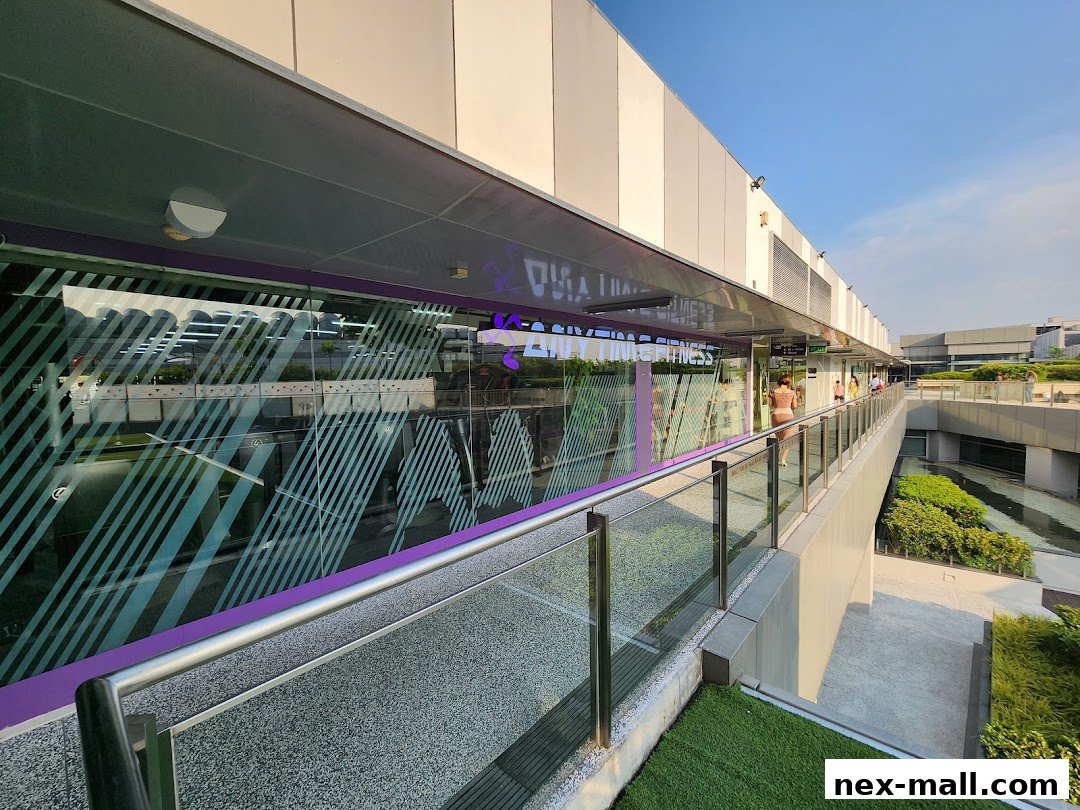Exterior view of Anytime Fitness NEX gym with large glass windows and purple accents.