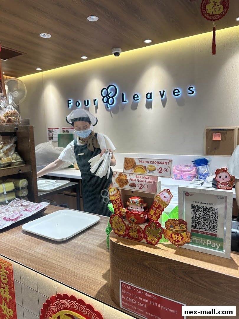 A bakery counter with a staff member serving customers and displaying pastries and festive decorations.