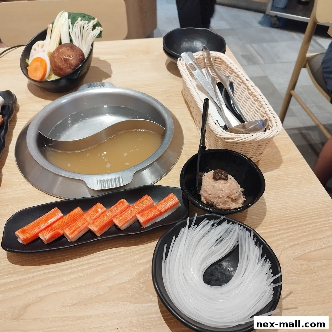 A table setting for Japanese hot pot with various ingredients and a pot of broth.