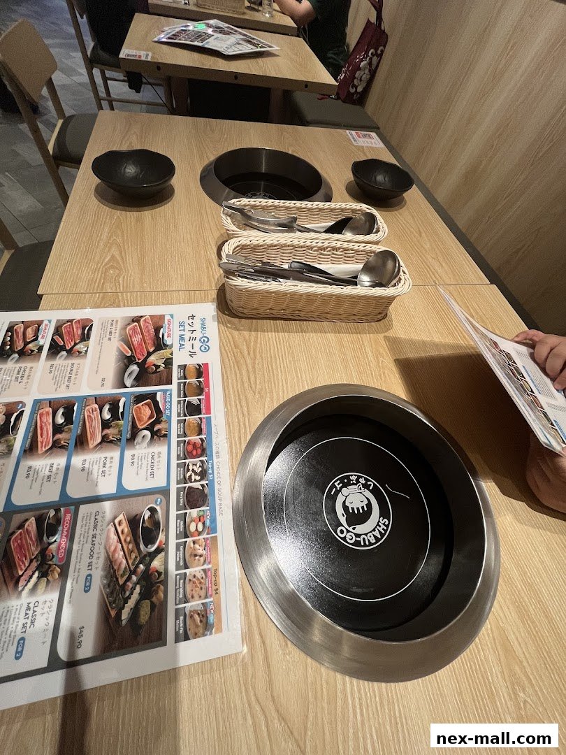 A table setting at SHABU-GO, featuring a menu, hot pot equipment, and cutlery.