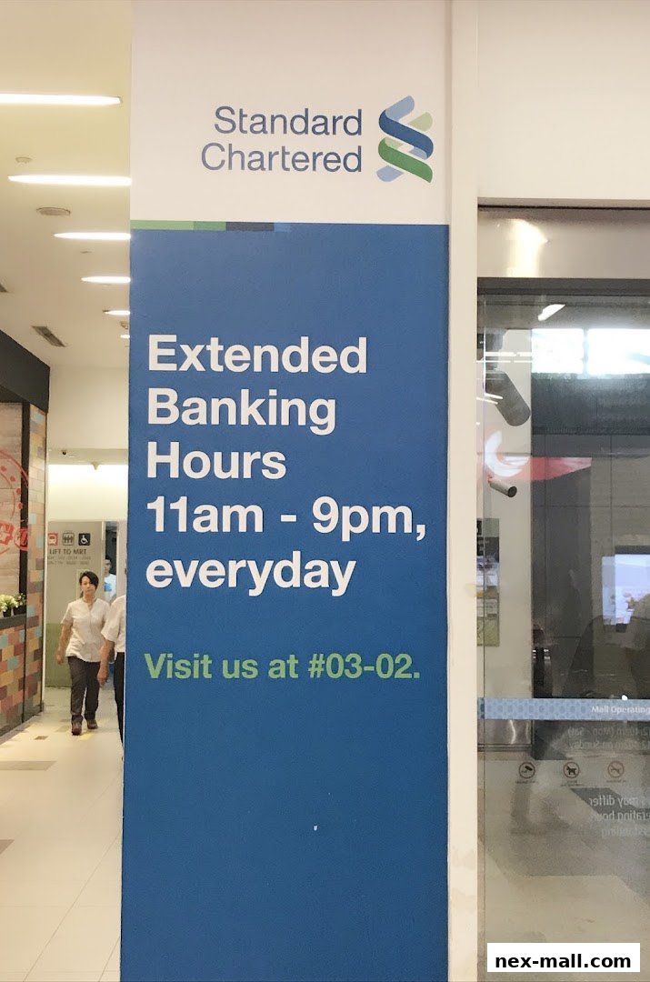 Signage for Standard Chartered Bank with extended banking hours and location.