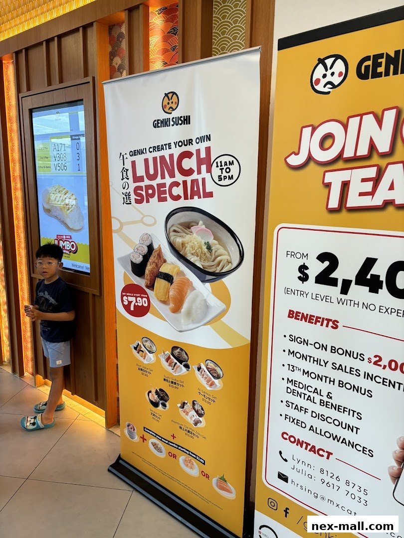 A young boy stands near a Genki Sushi promotional banner advertising a lunch special.