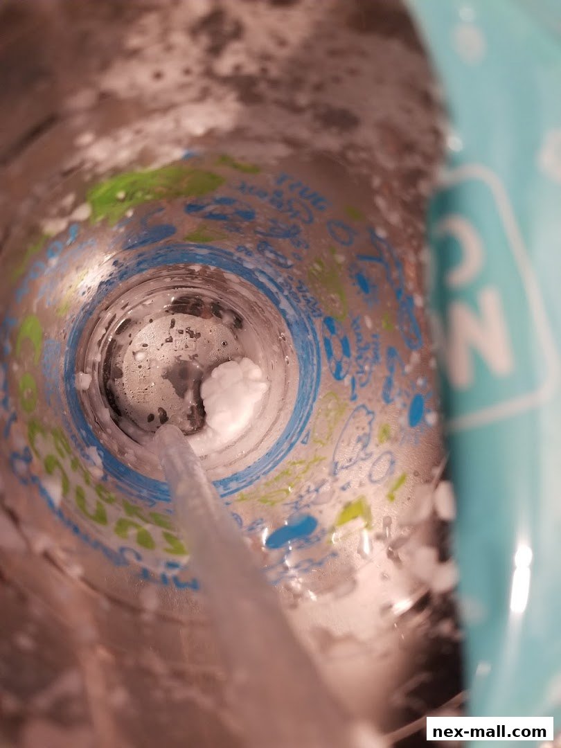 Close-up view inside a cup with a straw, showing remnants of a drink.
