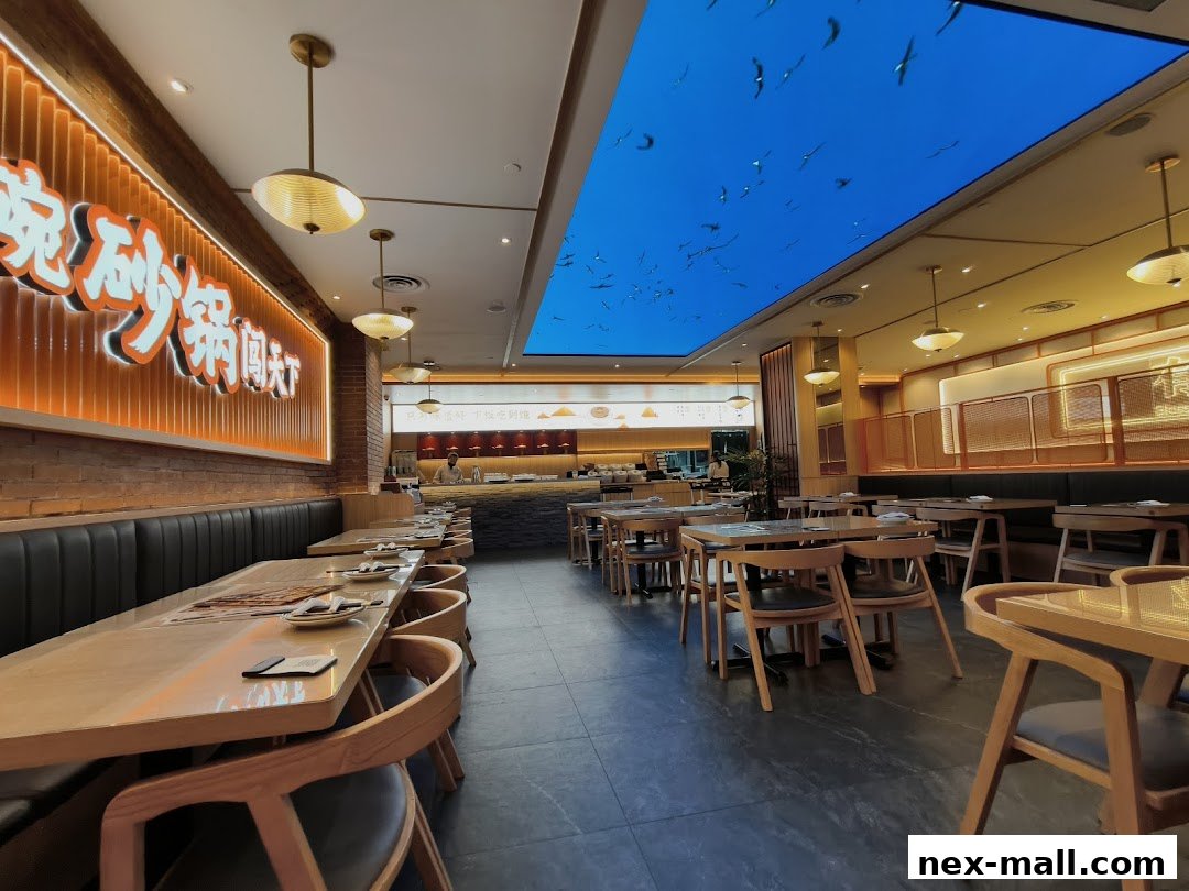 Interior view of a modern Chinese restaurant with tables, chairs, and illuminated signage.