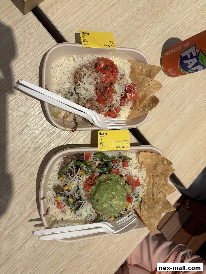 Two Guzman y Gomez bowls with rice, toppings, chips, and a Fanta drink.