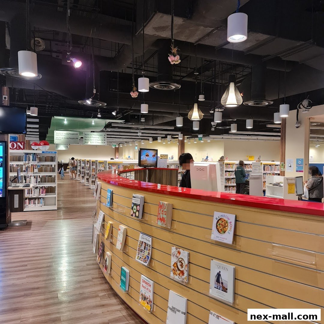 Interior view of a library with bookshelves, a service counter, and patrons.