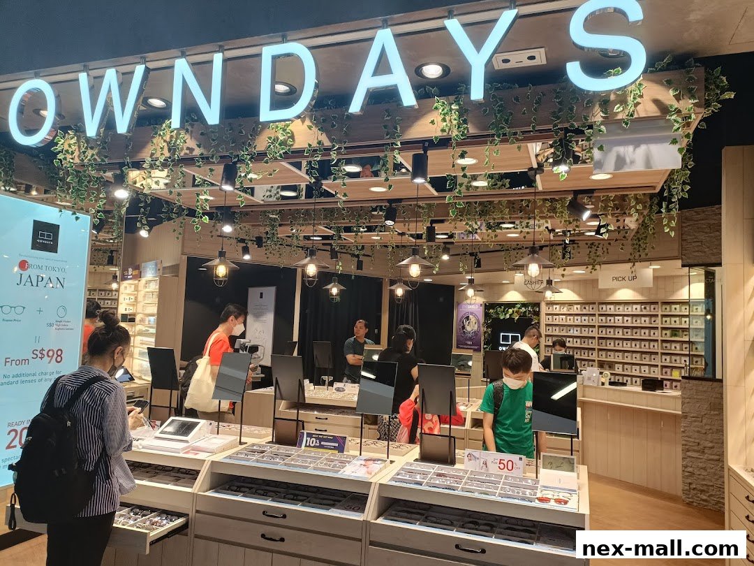 Interior view of an OWNDAYS optical shop with displays of eyeglasses and customers.