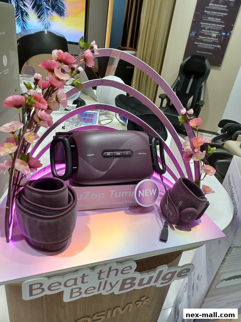 OSIM uZap Tummy abdominal massager with floral decor and a massage chair in the background.