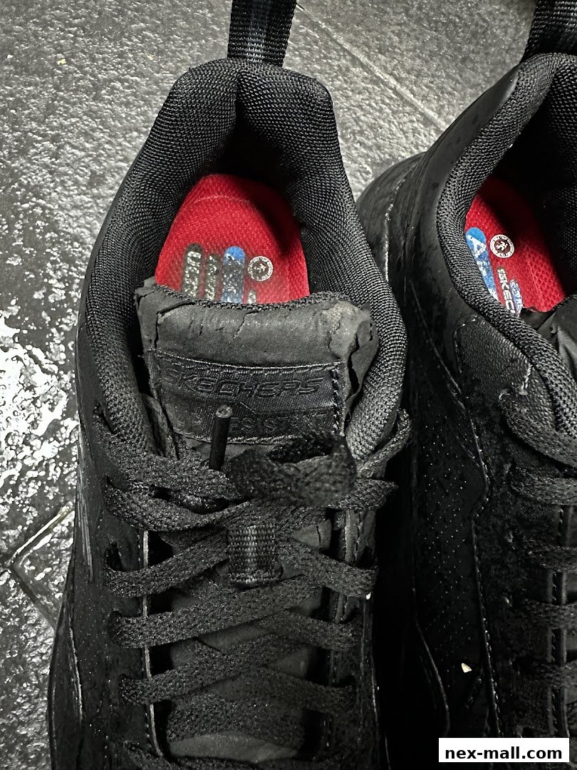 Close-up view of black Skechers shoes with red insoles and visible branding.