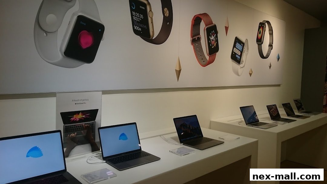 iStudio NEX shop interior showcasing Apple MacBook laptops and Apple Watch displays.