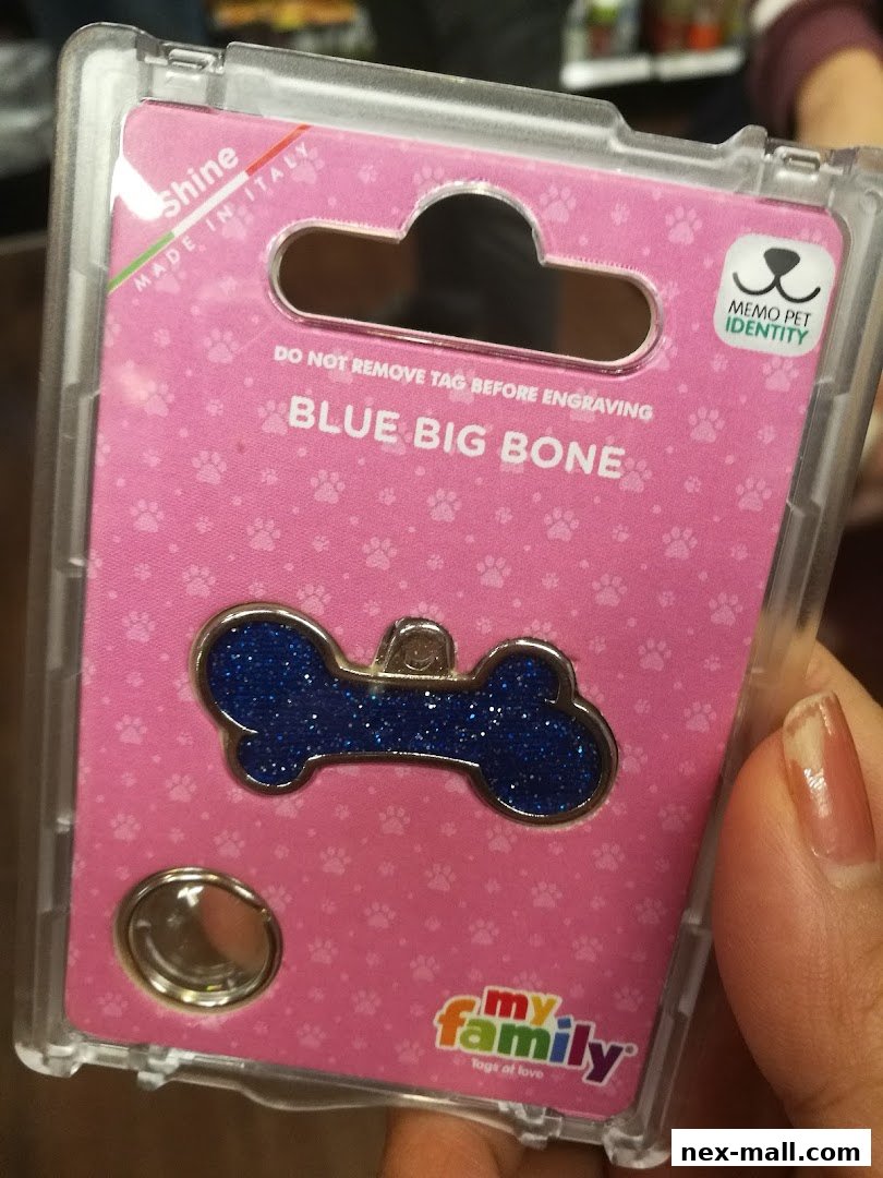 A person holds a packaged blue glittery bone-shaped pet tag made in Italy.