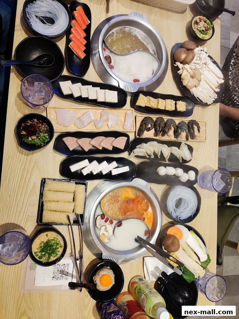 A table laden with various ingredients for Japanese hot pot, including meats, seafood, vegetables, and noodles.