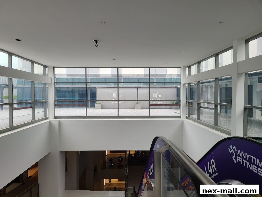 Interior view of a modern building with large windows and an escalator.