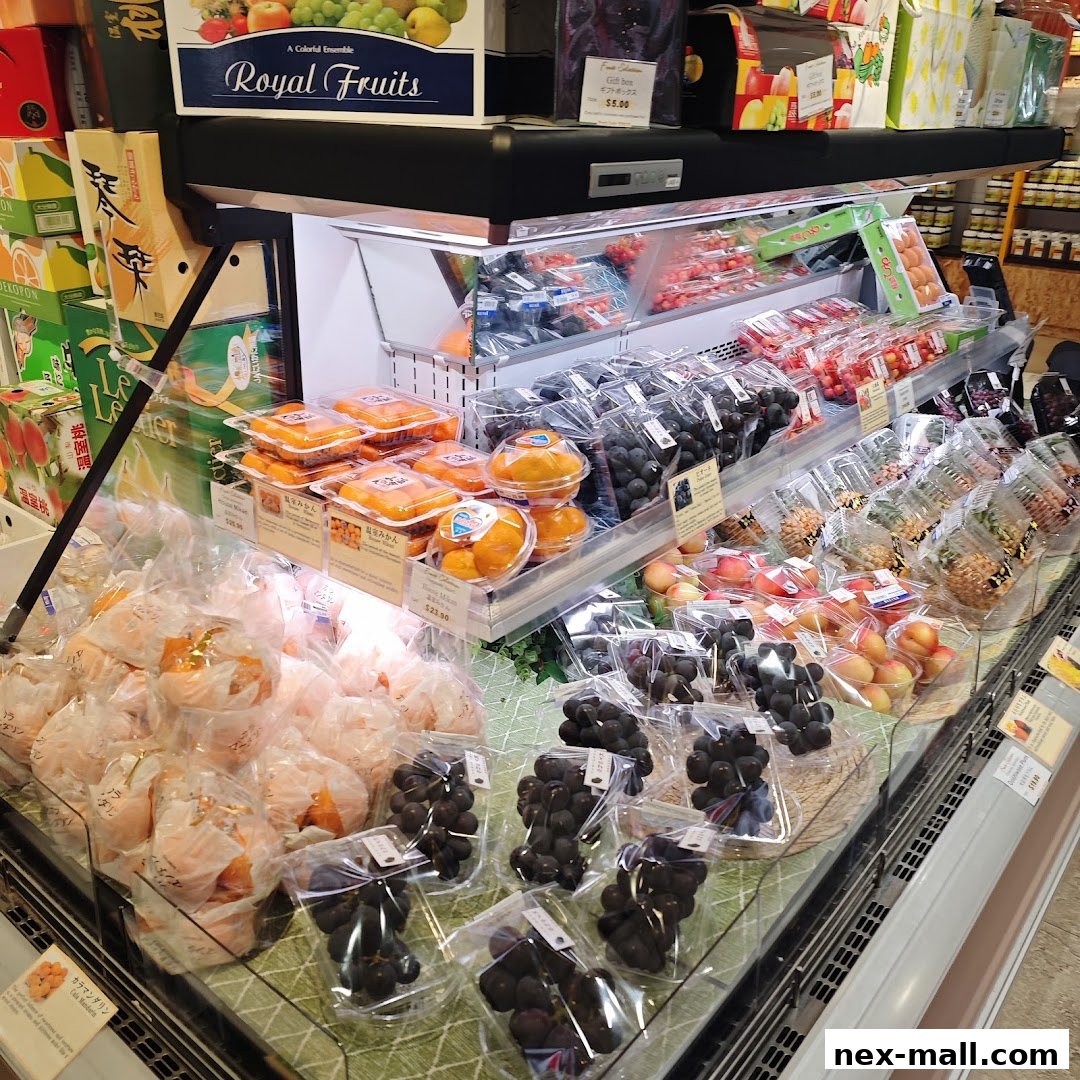 A display of various fresh fruits, including grapes, oranges, and peaches, neatly packaged.