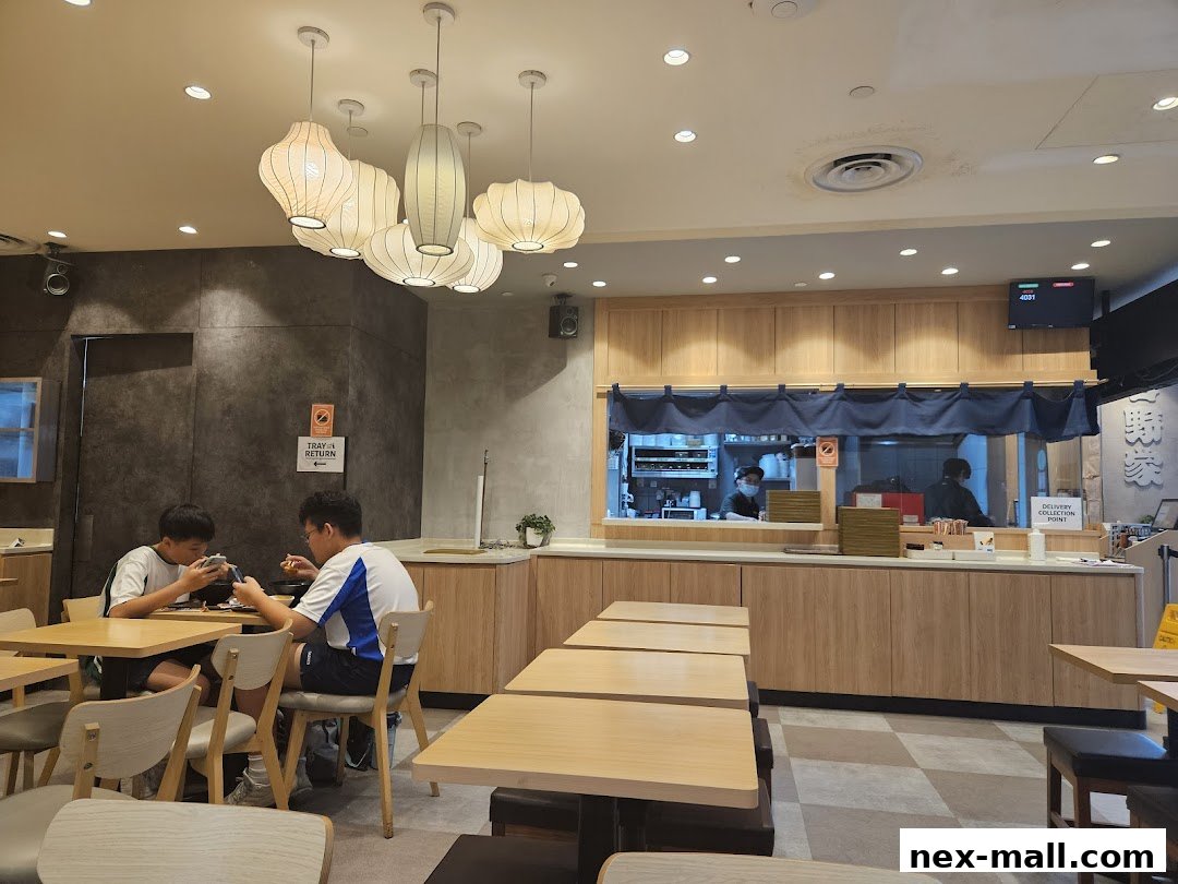 Interior of Yoshinoya - NEX with diners and kitchen staff visible.
