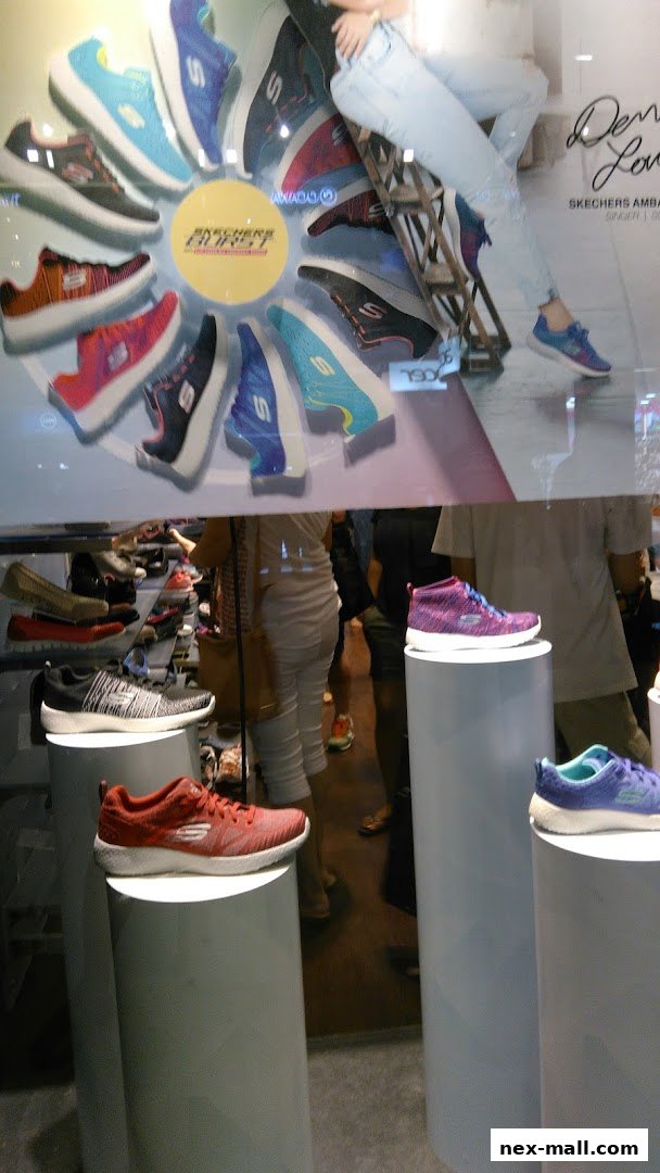 A display of Skechers shoes in a shop window and inside the store.
