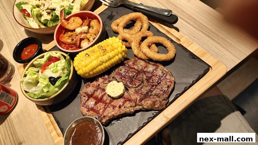 A delicious steak meal with sides of corn, onion rings, salad, and shrimp.