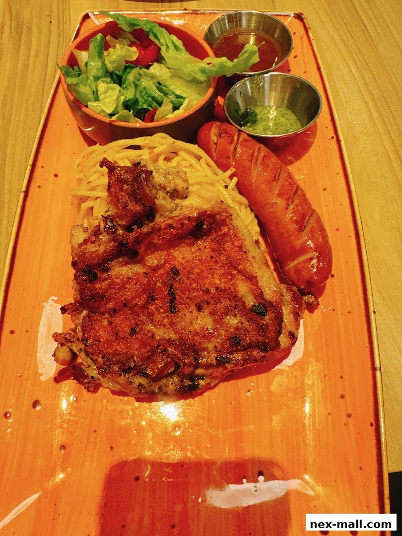 A delicious meal featuring grilled chicken, spaghetti, sausage, salad, and dipping sauces on an orange plate.