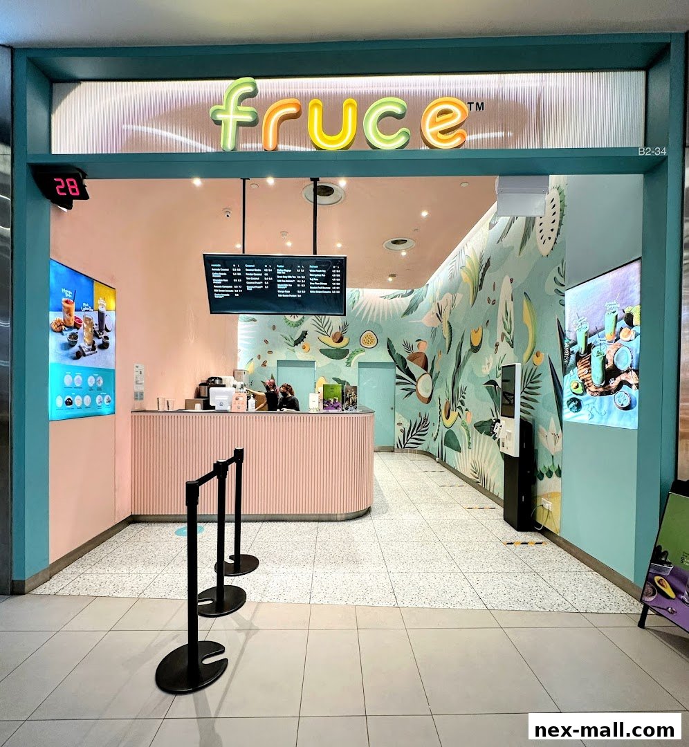 The Fruce NEX shop front features a pastel pink counter and vibrant tropical-themed wall art.
