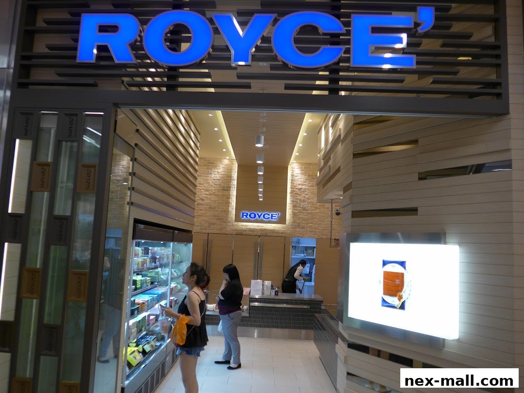 The entrance to a Royce shop with illuminated signage and display cases.