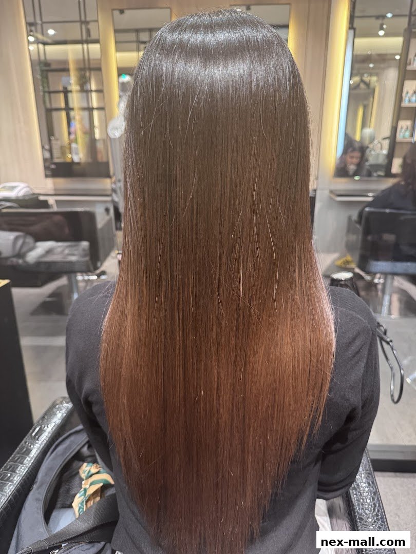 A person's back with long, straight, brown hair with subtle reddish highlights.