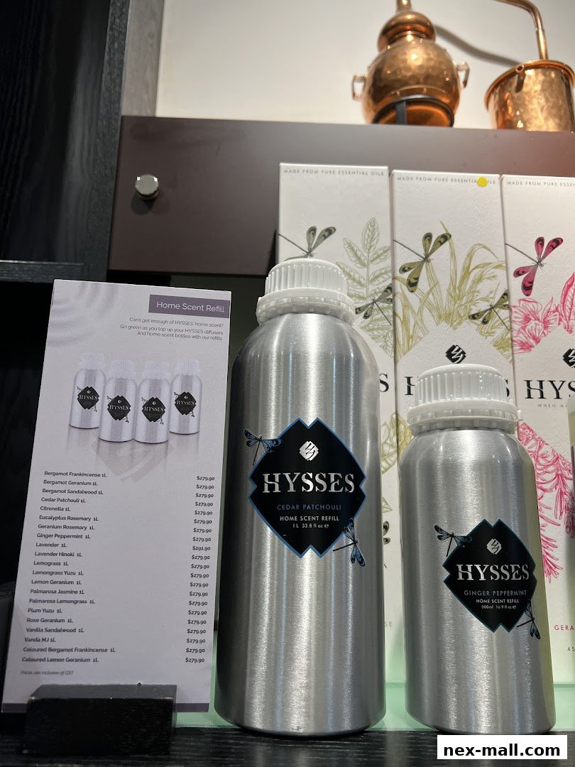 A display of HYSSES home scent refills in large aluminum bottles with product information.