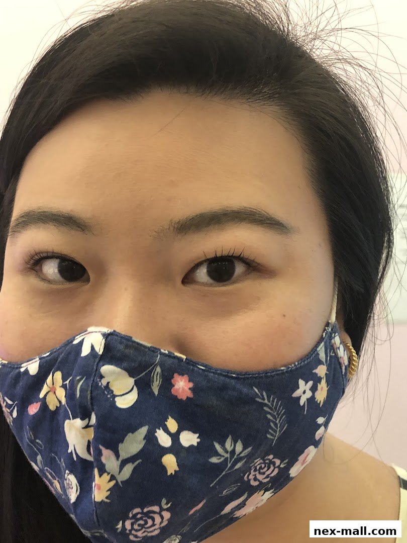 Close-up of a woman's eyes and face wearing a floral face mask.