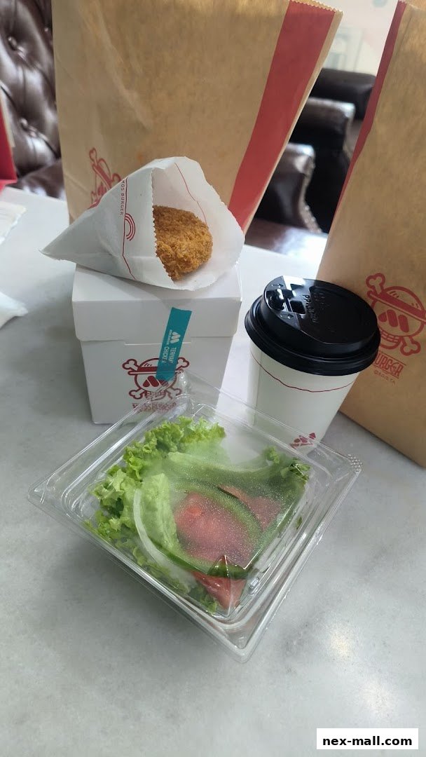 A MOS Burger meal featuring a fried item, salad, and a drink with branded bags.