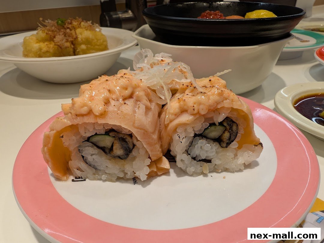 Close-up of delicious sushi rolls with torched salmon and a side of fried tofu.