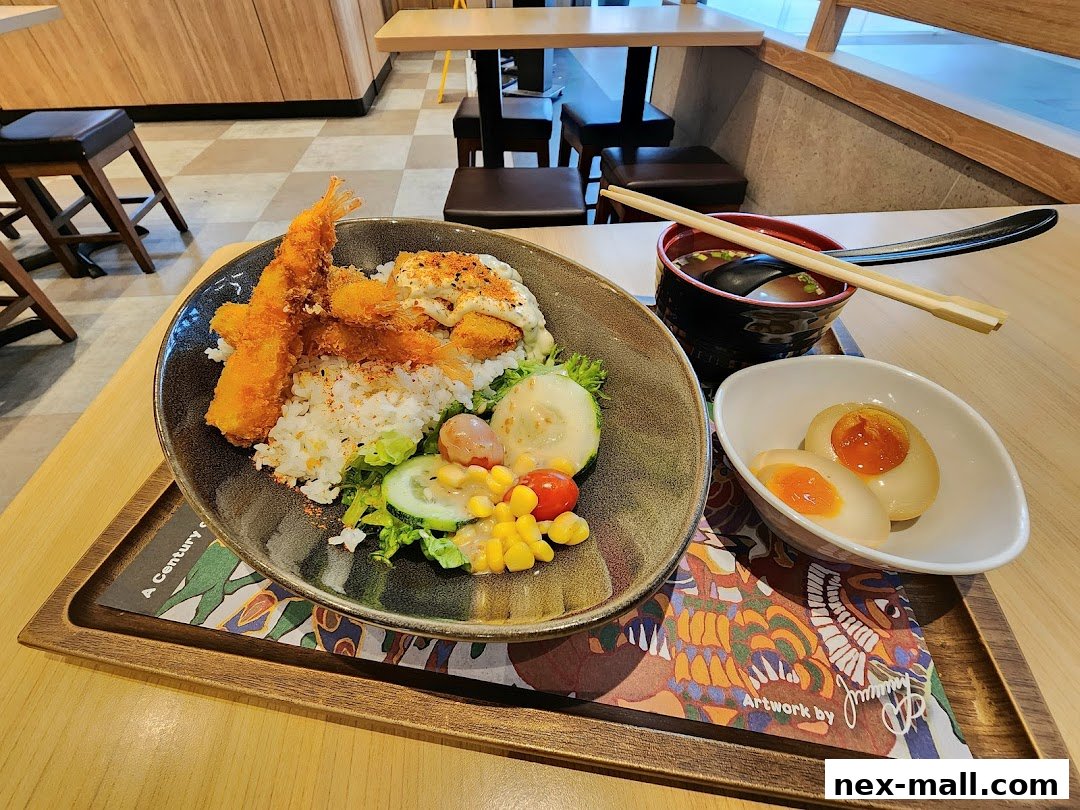 A delicious Yoshinoya meal featuring fried shrimp, rice, salad, soup, and a soft-boiled egg.