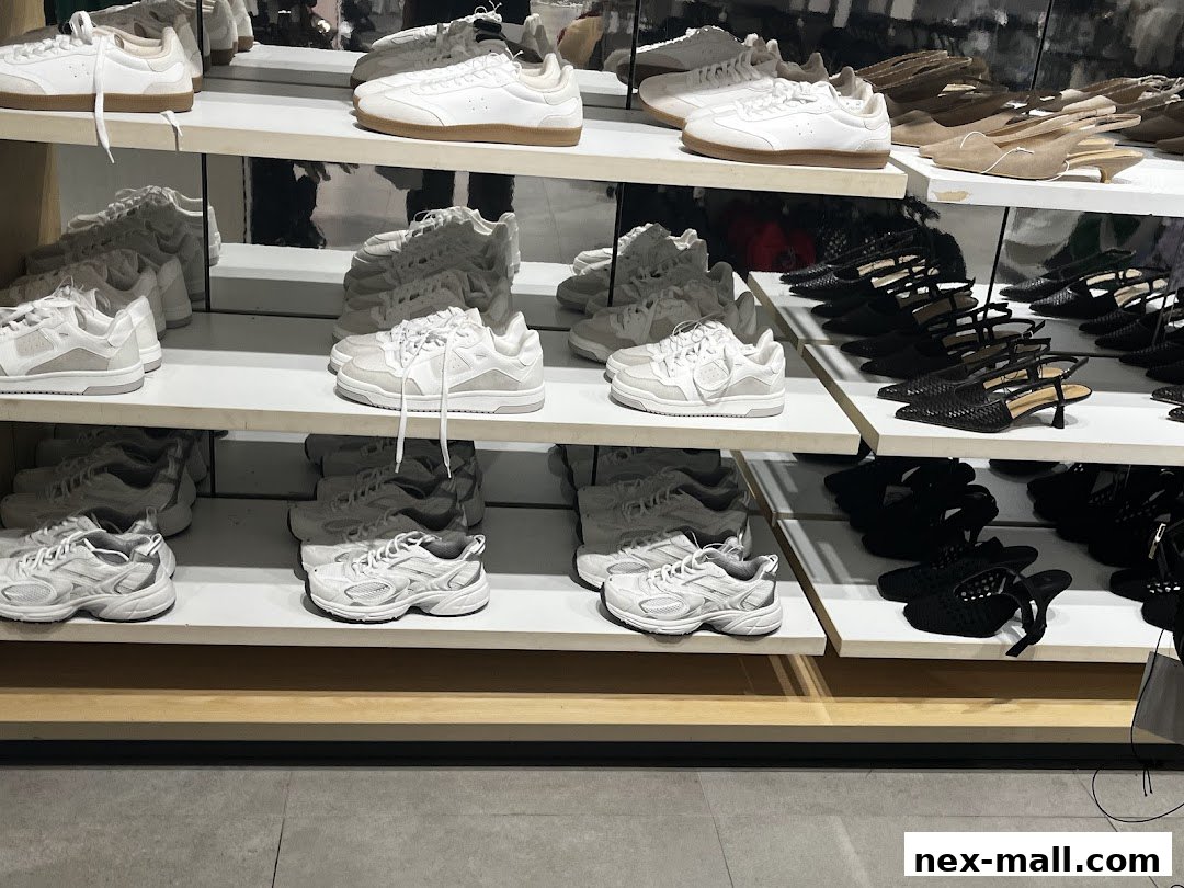 A display of various shoes, including sneakers and heels, neatly arranged on shelves.
