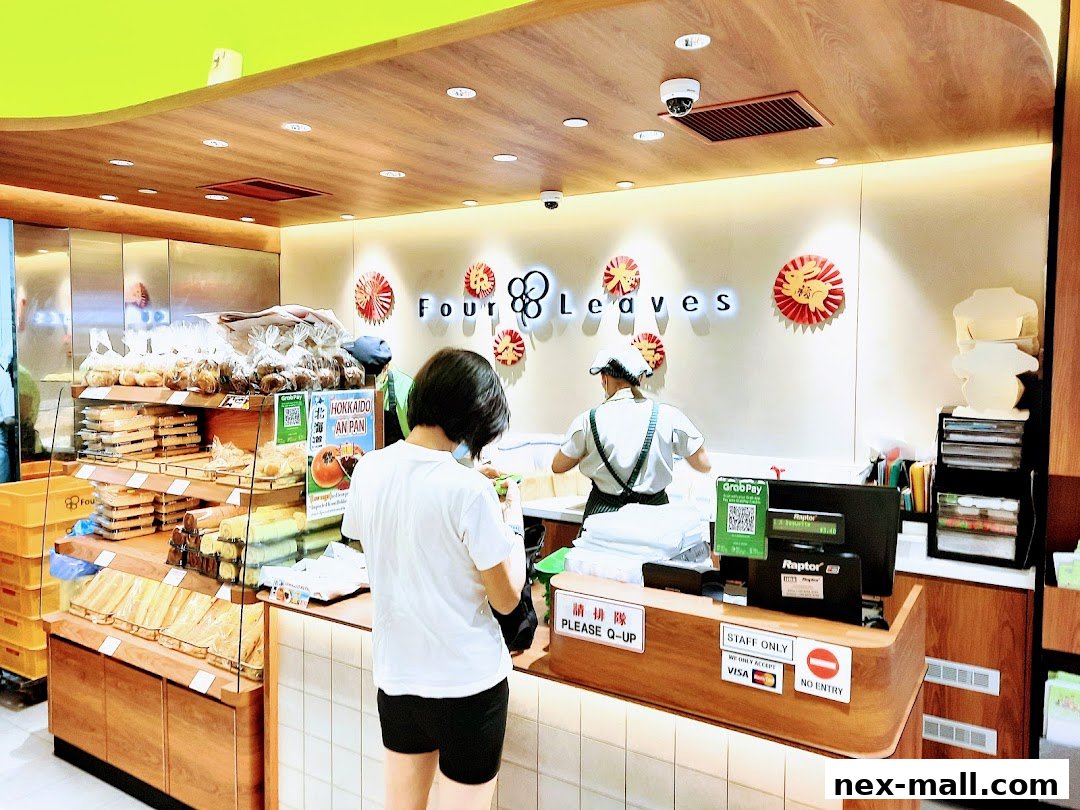 A customer is at the counter of a bakery with displays of bread and pastries.