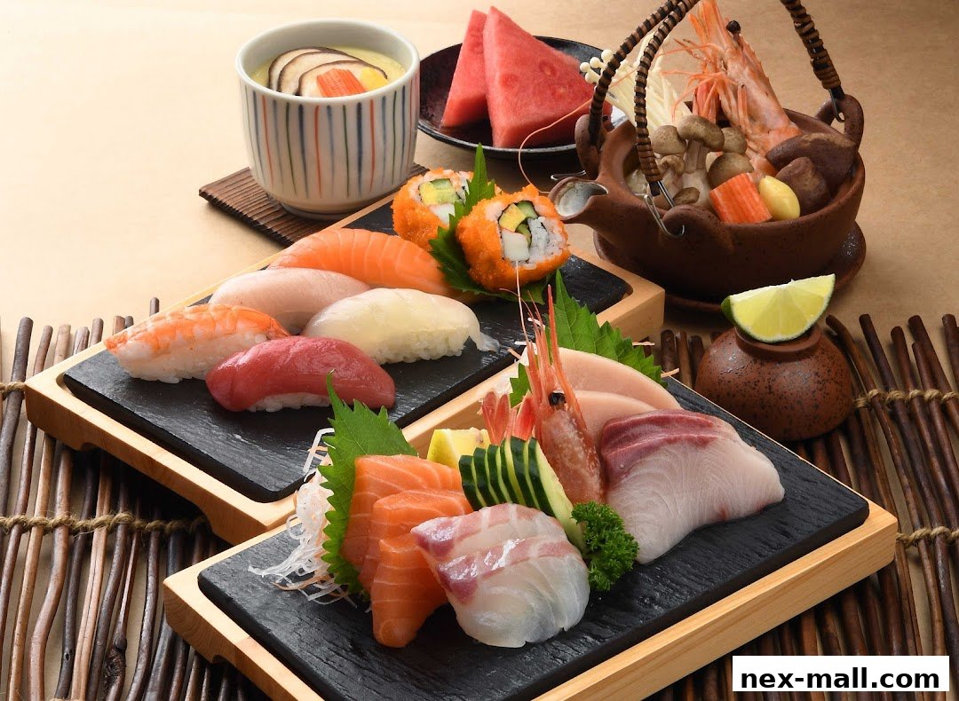 A beautifully arranged platter of assorted sushi and sashimi, with a side of chawanmushi and fruit.