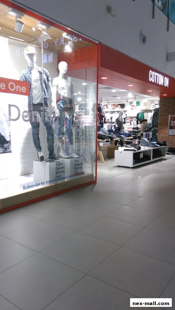 Cotton On store interior with mannequins displaying denim jeans and clothing racks visible.