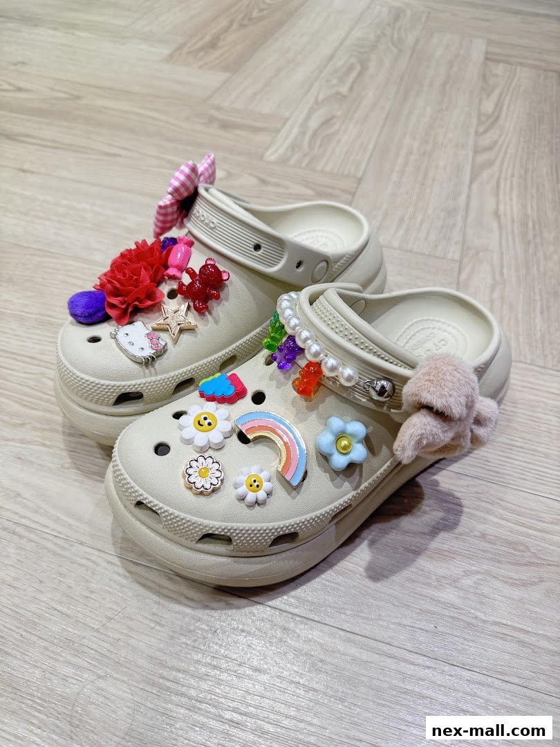 A pair of beige Crocs adorned with colorful Jibbitz charms and fluffy accessories.