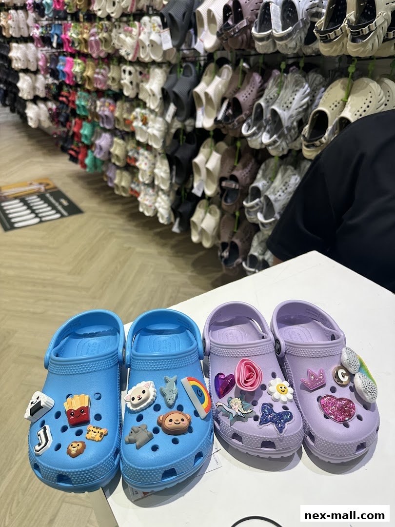 A display of colorful Crocs shoes and Jibbitz charms in a retail store.