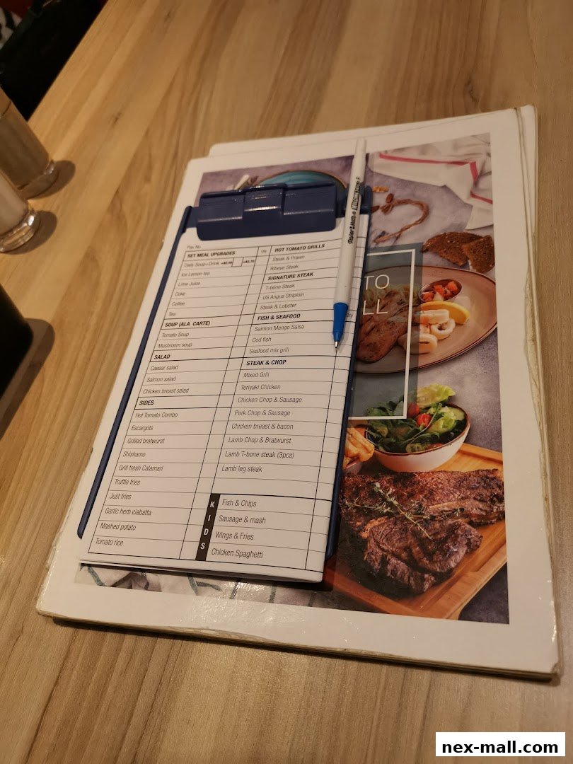 A menu from Hot Tomato featuring various grilled dishes, seafood, salads, and sides.