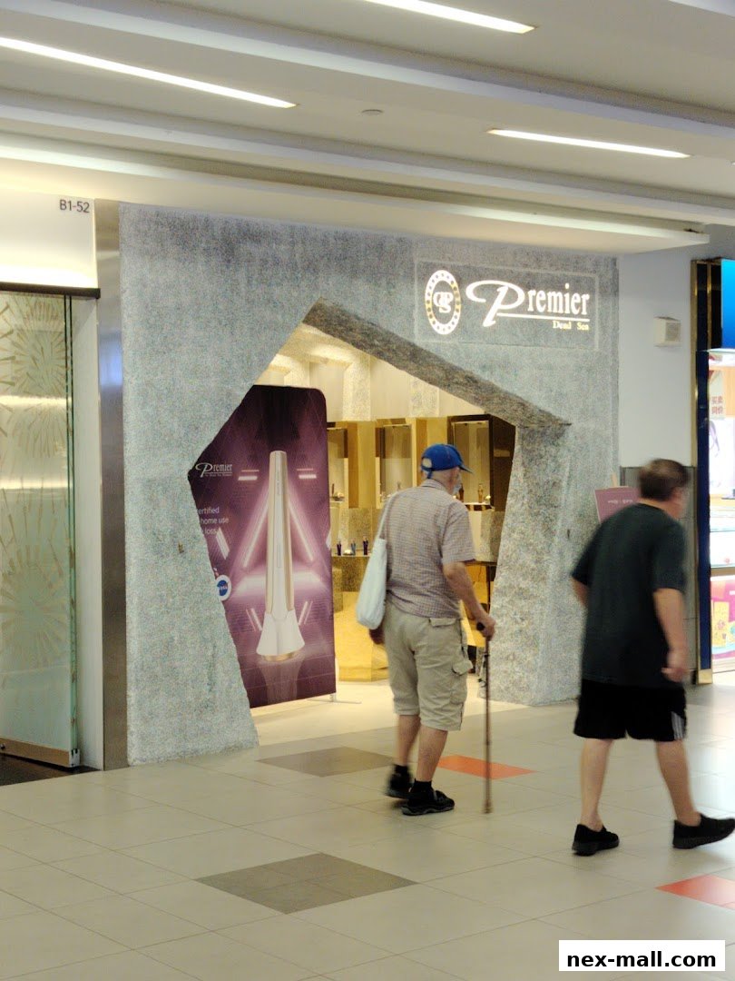 The entrance to Premier Dead Sea NEX shop with people walking by.