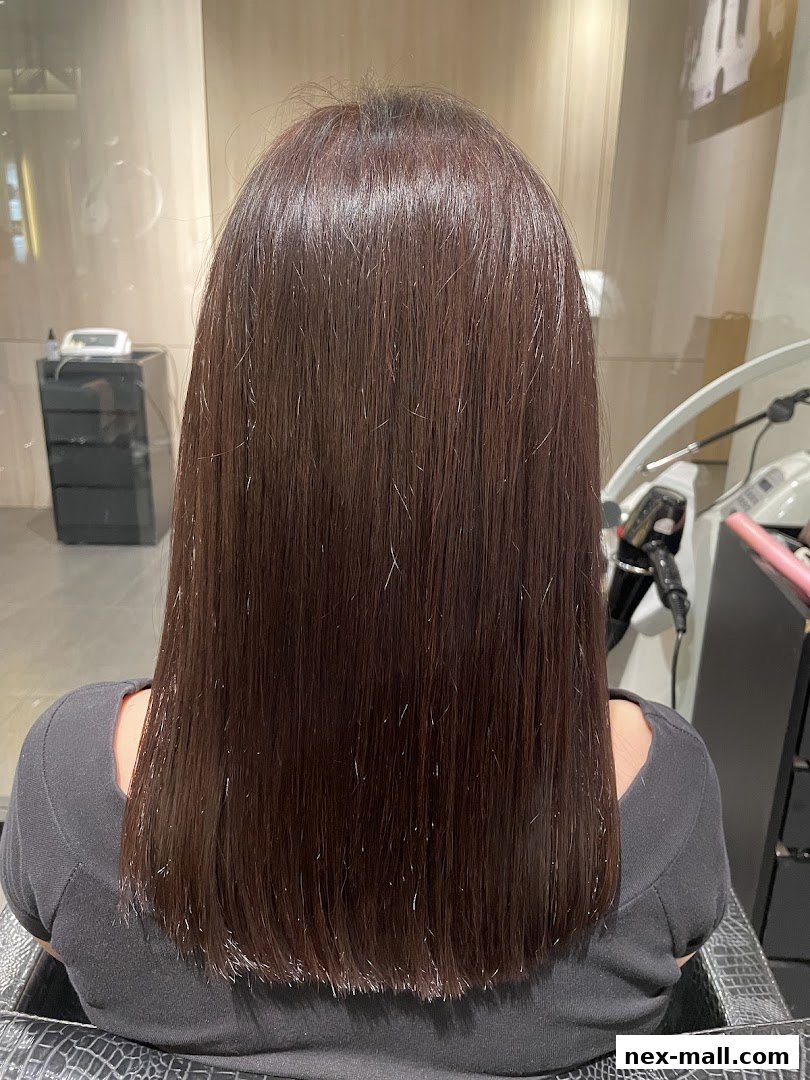 A person's back with long, straight, dark brown hair, showcasing a recent haircut.