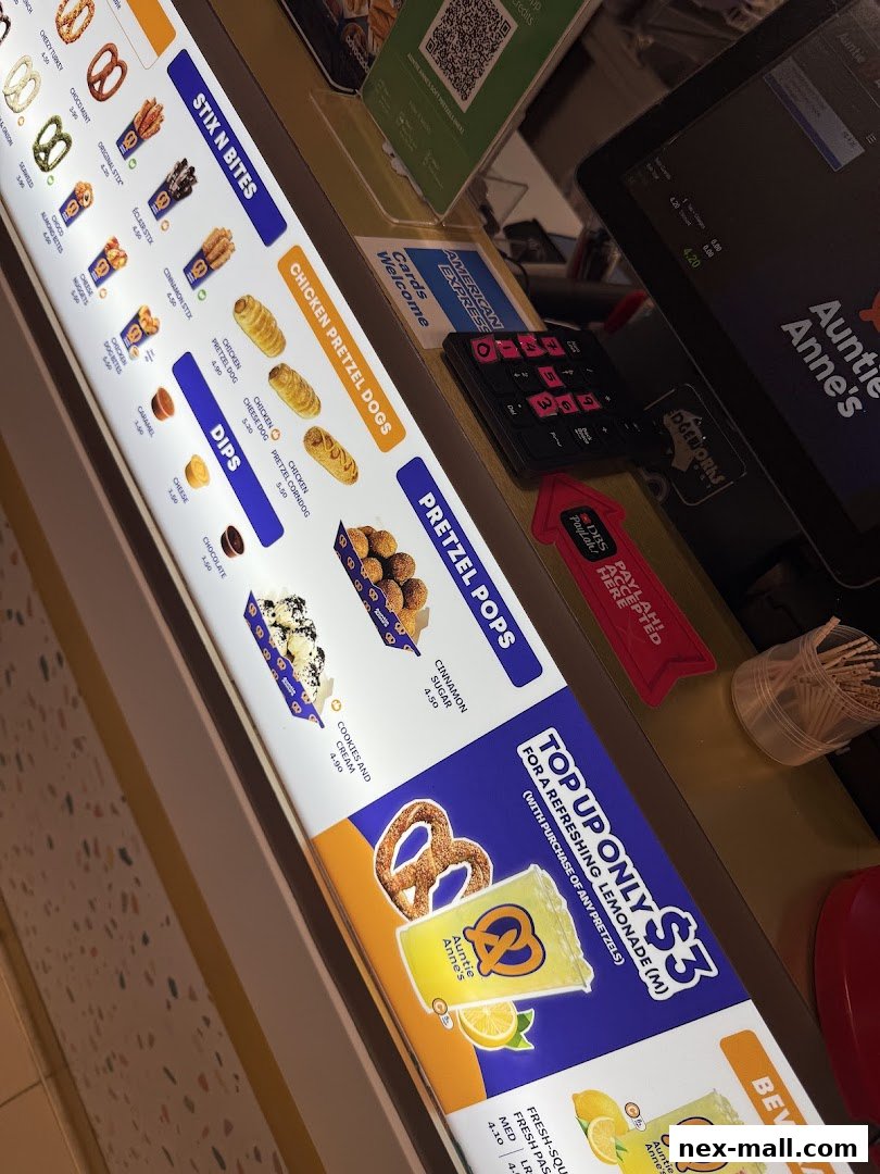A close-up view of the Auntie Anne's pretzel menu board with various pretzel options and drinks.