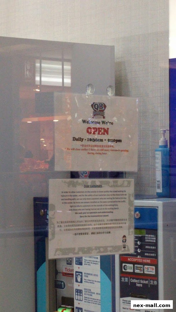 QB House NEX shop front with an open sign and customer information.