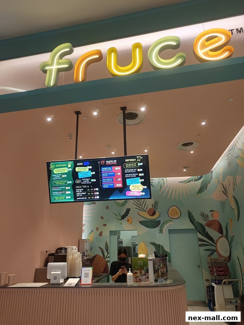 A brightly lit Fruce NEX shop with a digital menu displaying various fruit drinks and acai bowls.