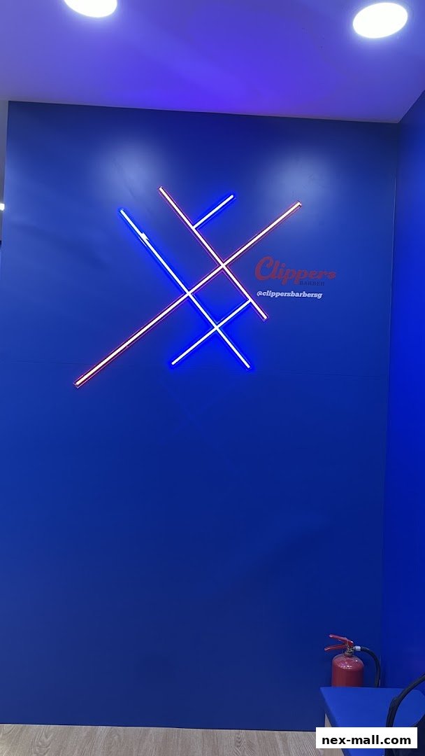 A blue wall with neon lights and the Clippers Barber logo.