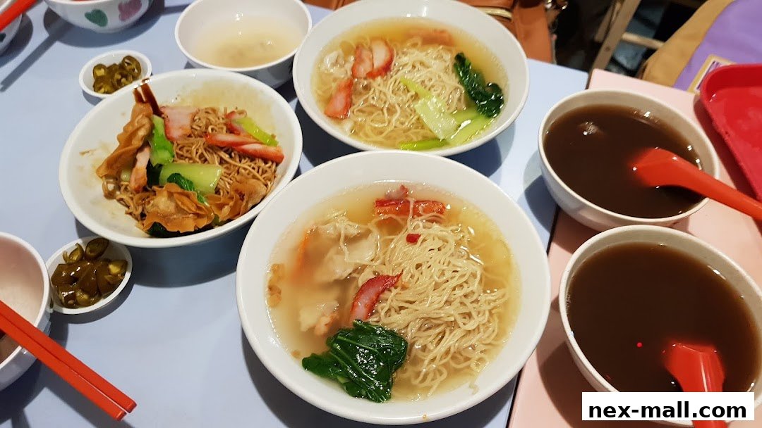 A table laden with bowls of noodles, soup, and pickled chilies.
