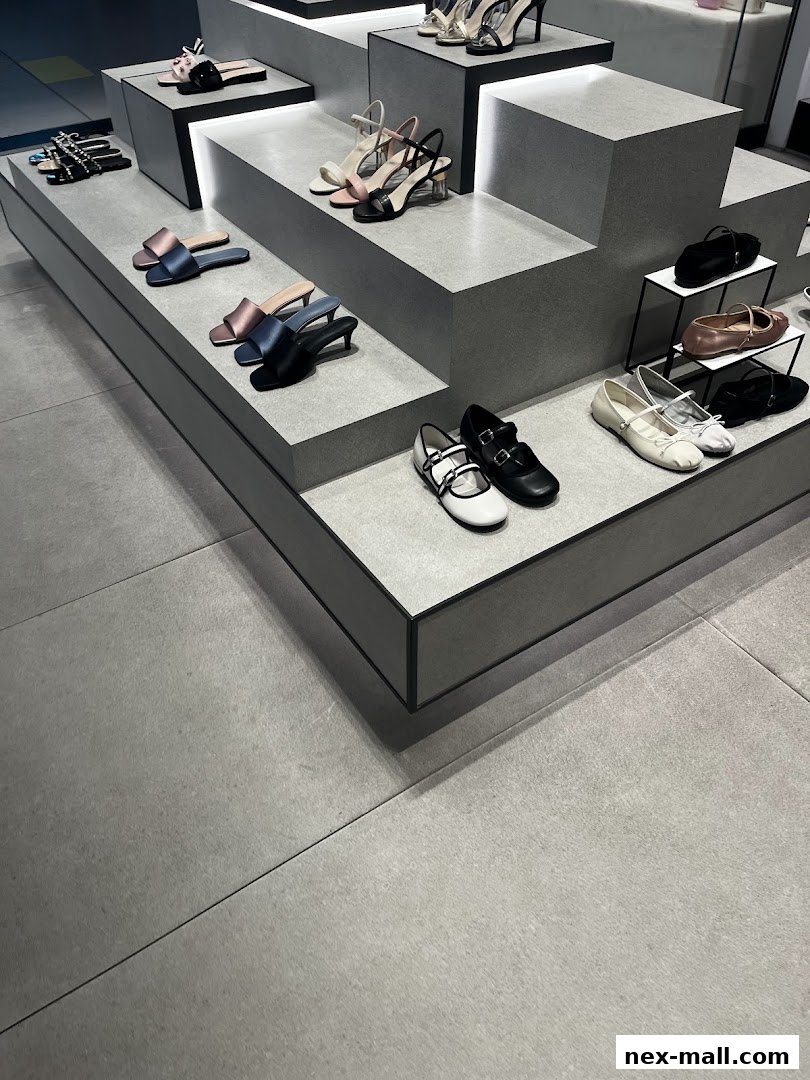 A display of various women's shoes, including heels, flats, and sandals, on tiered shelves.